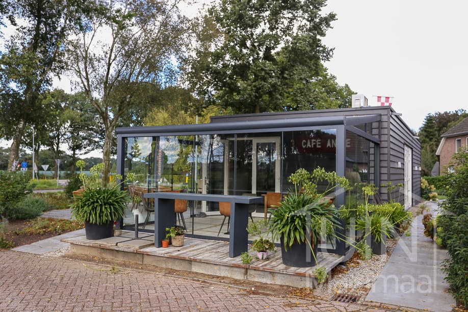 Anthrazitfarbene Terrassenüberdachung an modernem Gartenhaus Anthrazitfarbene Terrassenüberdachung an modernem Gartenhaus