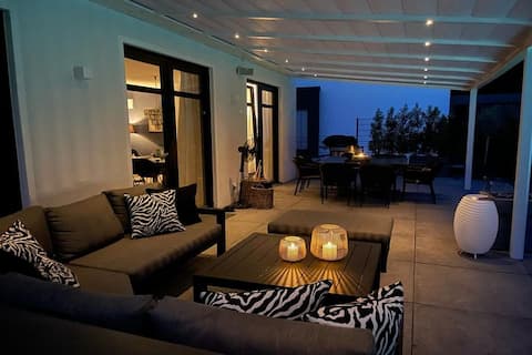 Matt schwarze Terrassenüberdachung mit Loungesofa
