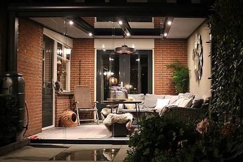 Veranda mit Stimmungsbeleuchtung und Glasschiebewänden