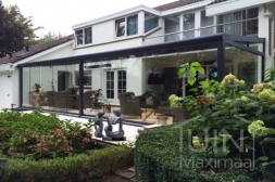 Anthrazitfarbene Glasschiebetür in angebauter, moderner Terrassenüberdachung mit Polycarbonatdach Anthrazitfarbene Glasschiebetür in angebauter, moderner Terrassenüberdachung mit Polycarbonatdach