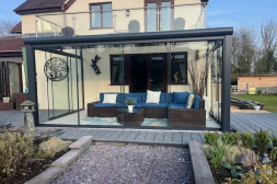 Terrassenüberdachung mit Glasschiebewänden und anthrazitfarbenen Türgriffen